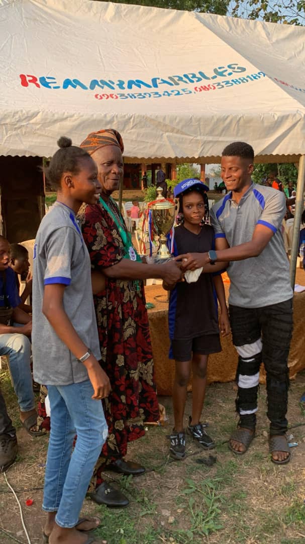 A Sound Mind Schools student receiving a championship trophy from a guest of honour