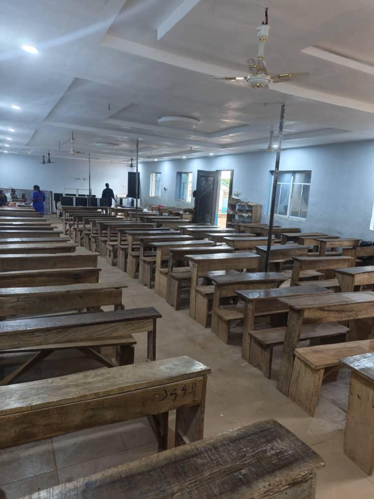 A large classroom hall at Sound Mind Schools with rows of desks