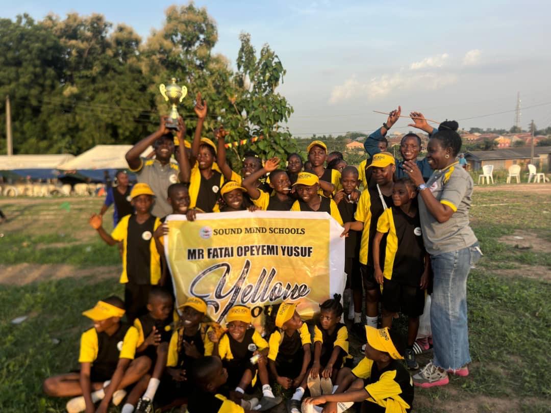 Students of the Yellow house celebrating with their trophy on inter-house sports day